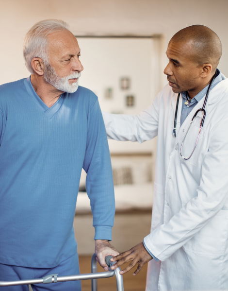african-american-doctor-helping-senior-man-use-walker-nursing-home